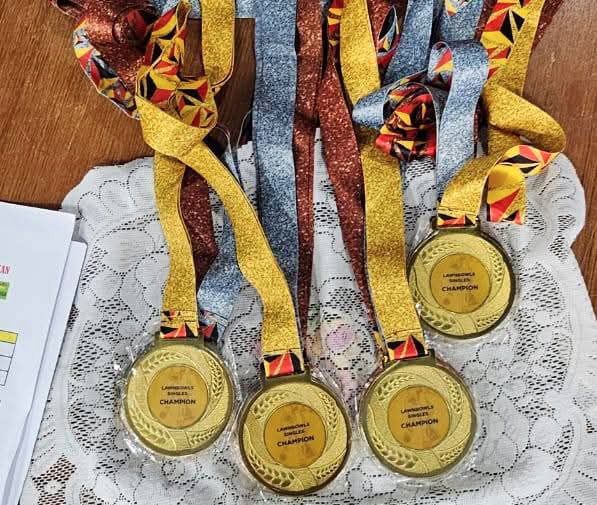 A table with a white cloth and five gold medals on it.

AI generated content