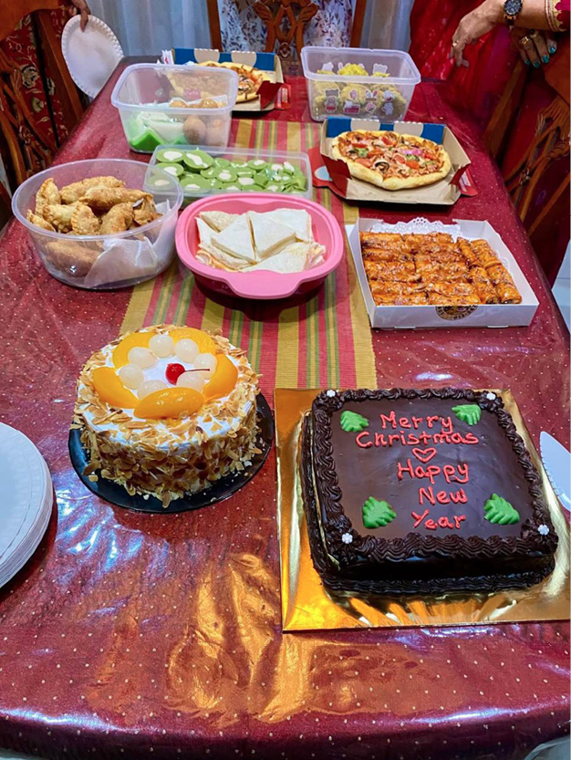 A table is set with a variety of food, including cakes, pizza, and sandwiches. There are also plates and bowls of food on the table. A person is present in the background, and a chair is visible in the foreground.

AI generated content