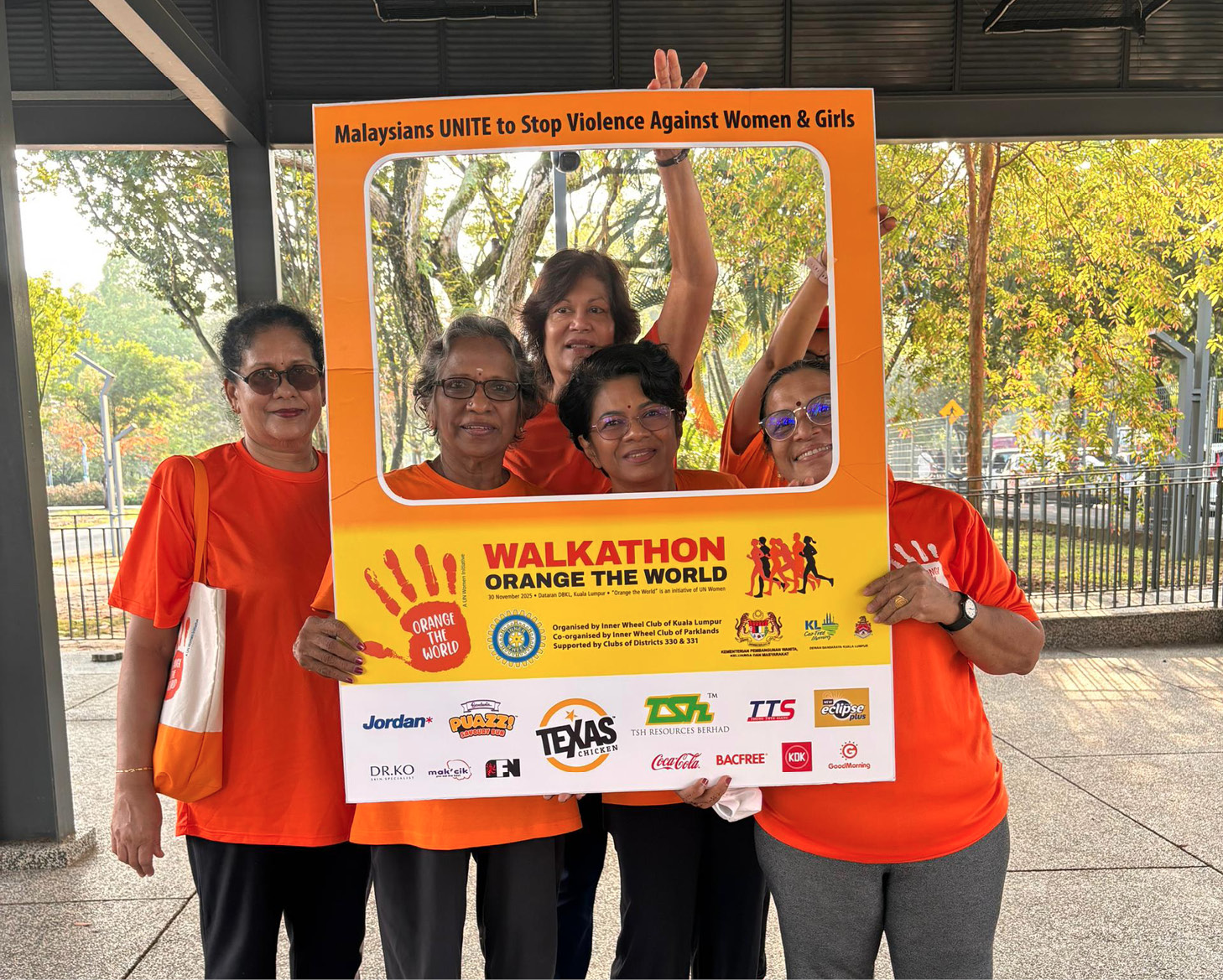 Four women wearing orange shirts pose for a picture in front of a sign.

AI generated content