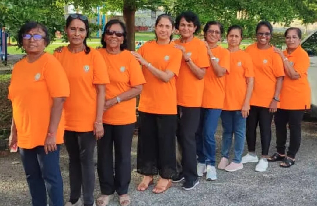 A group of women wearing orange shirts and black pants pose for a picture.
AI generated content