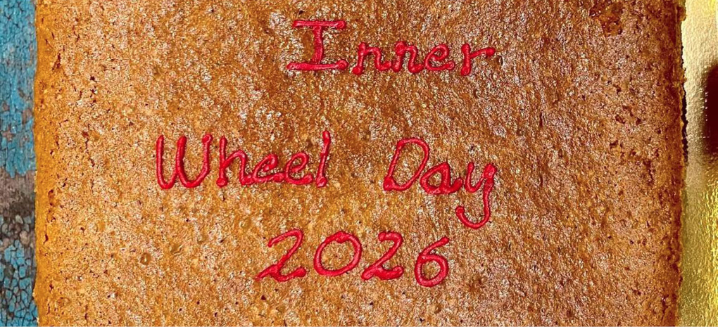 A square cake with the words International Inner Wheel Day 2026 written in red icing on top.
Description generated by AI