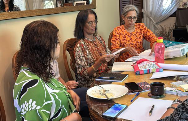 Three women are sitting around a dining table, reading books.

AI generated content