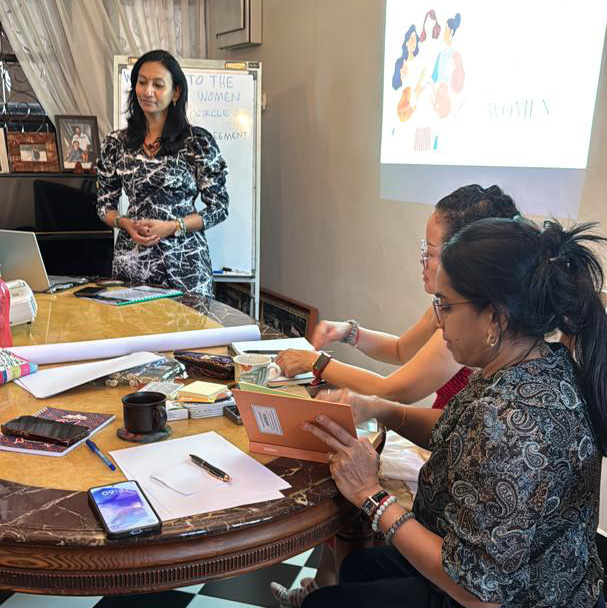 Three women are sitting around a table, looking at a projector screen. They are using cell phones and a laptop to work on a project.

AI generated content
