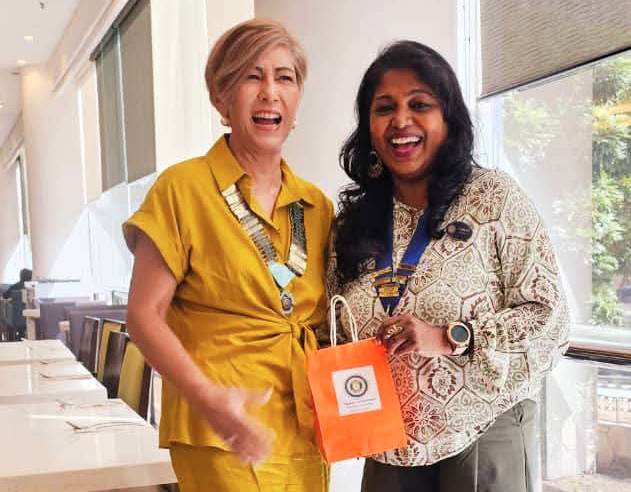 Two women in a restaurant, one holding an orange bag.
AI generated content