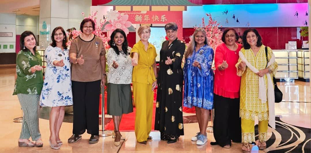 A group of women pose for a picture in front of a red wall.
AI generated content