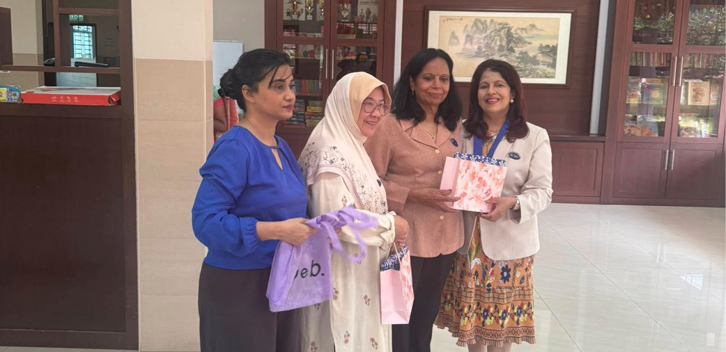 Four women are standing together in a room, holding pink items.

AI generated content
