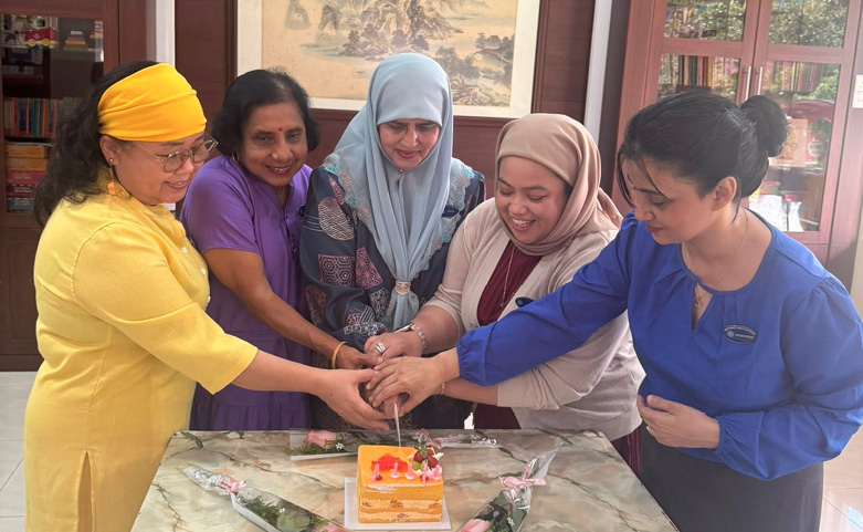 A group of women are gathered around a table, cutting a cake together.

AI generated content