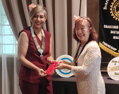 Two women are standing in front of a table with a framed award.

AI generated content