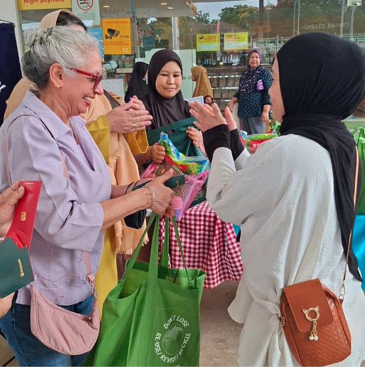 People are standing and interacting near a building entrance with a yellow sign, some holding bags and wearing casual clothing.
Description generated by AI