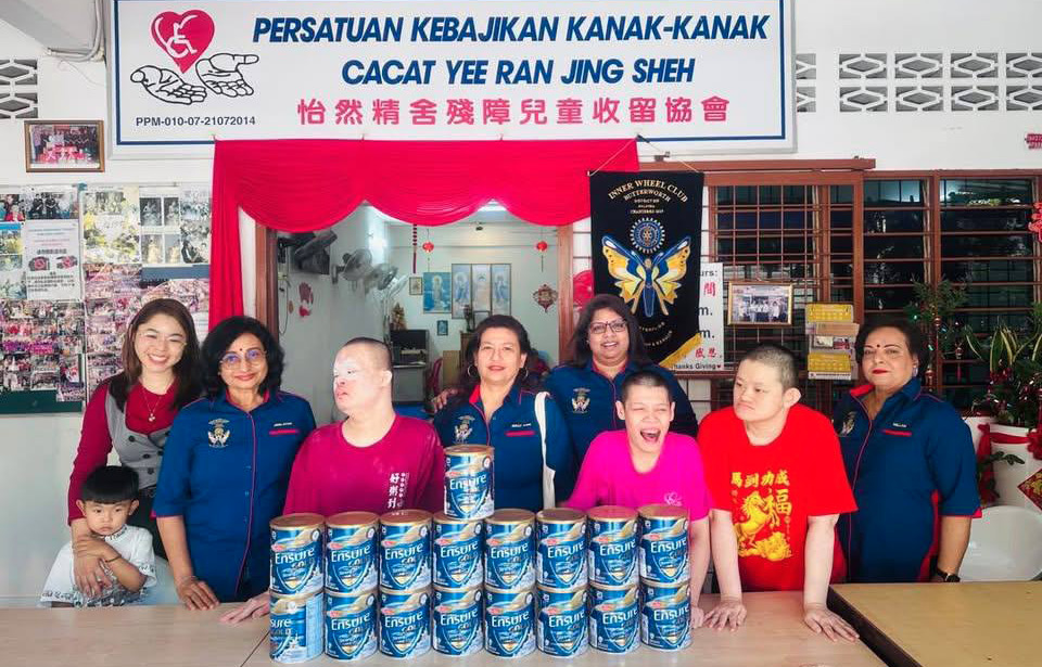 A group of people, including children, pose in front of a table with stacks of canned food.
AI generated content