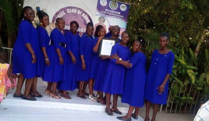 A group of women in blue dresses stand on a stage, holding a certificate.
AI generated content
