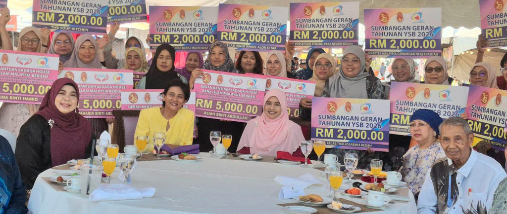 A group of people sitting and standing around a large round table under a decorated tent, holding colorful signs with monetary amounts and smiling.
Description generated by AI